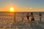 generatieZ en mentale gezondheid wat kan je als werkgever doen/ voetballen op het strand met ondergaande zon