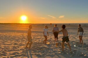 generatieZ en mentale gezondheid wat kan je als werkgever doen/ voetballen op het strand met ondergaande zon